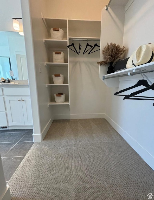 spacious closet with dark colored carpet