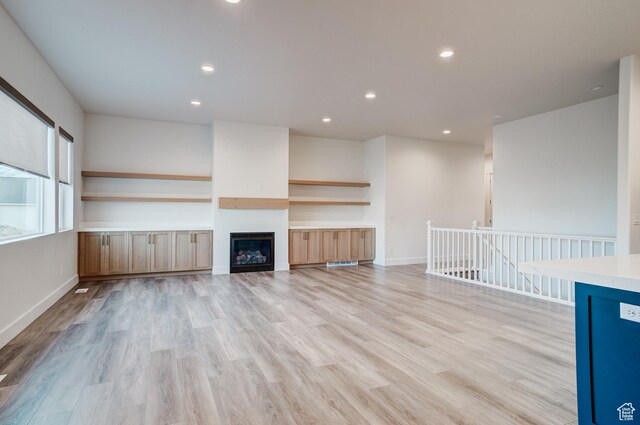 1259 W Moon Way Unit 134, Riverton, UT 84065 - unfurnished living room with a fireplace and light wood-type flooring