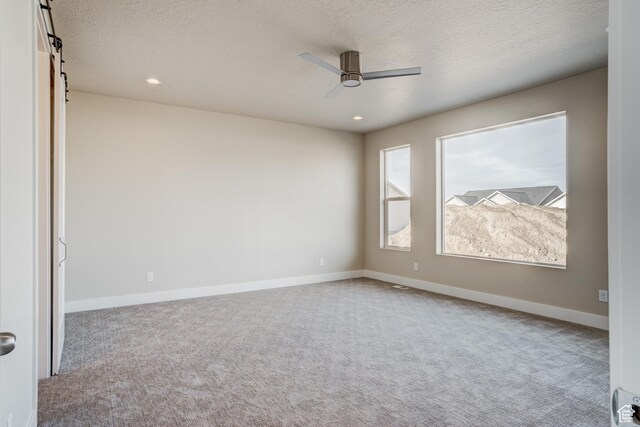 1259 W Moon Way Unit 134, Riverton, UT 84065 - carpeted spare room with ceiling fan, a barn door, and a textured ceiling