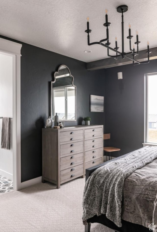 carpeted bedroom with a textured ceiling and a notable chandelier