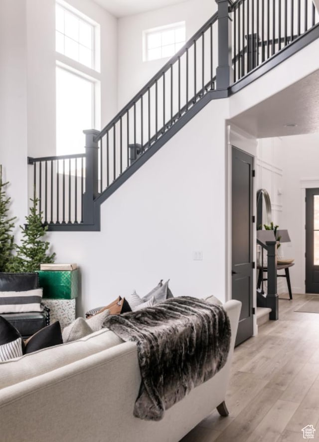 living room featuring light hardwood / wood-style floors and a high ceiling