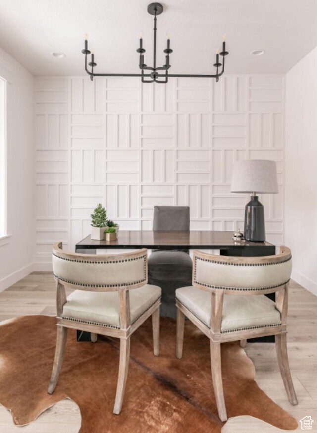 dining area featuring light hardwood / wood-style flooring and an inviting chandelier