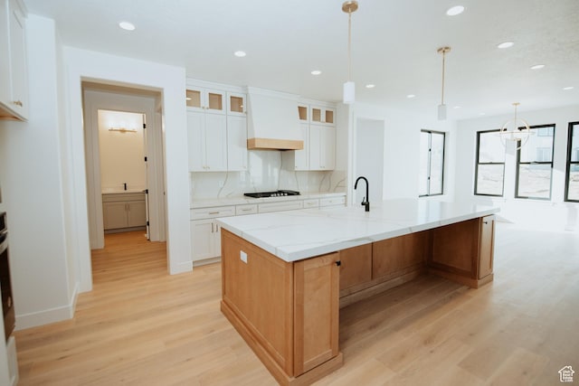 1165 N 360 E Unit 75, Salem, UT 84653 - kitchen with a spacious island, light stone countertops, white cabinets, decorative light fixtures, and custom exhaust hood