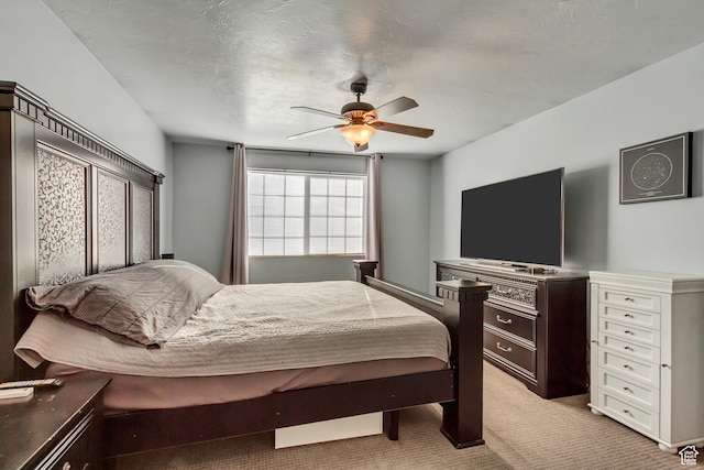 bedroom with light colored carpet and a ceiling fan
