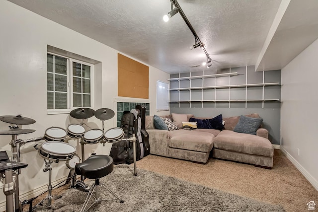 sitting room with carpet floors, rail lighting, a textured ceiling, baseboards, and a tile fireplace