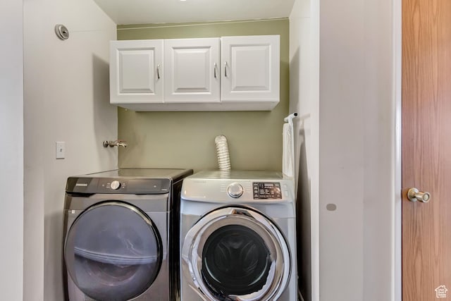 washroom with washing machine and dryer and cabinet space