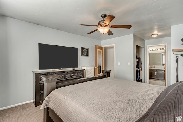 bedroom with light colored carpet, connected bathroom, baseboards, and ceiling fan