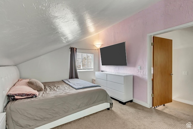 bedroom featuring vaulted ceiling, light carpet, and baseboards