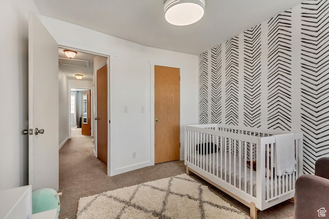 carpeted bedroom with an accent wall, wallpapered walls, and baseboards