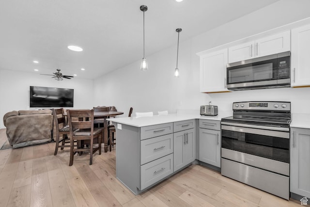 13963 S Wide Ridge Way Unit 1121, Herriman, UT 84096 - kitchen with kitchen peninsula, stainless steel appliances, decorative light fixtures, white cabinets, and gray cabinets