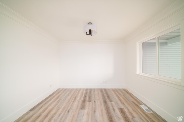 unfurnished room featuring ornamental molding and light hardwood / wood-style flooring