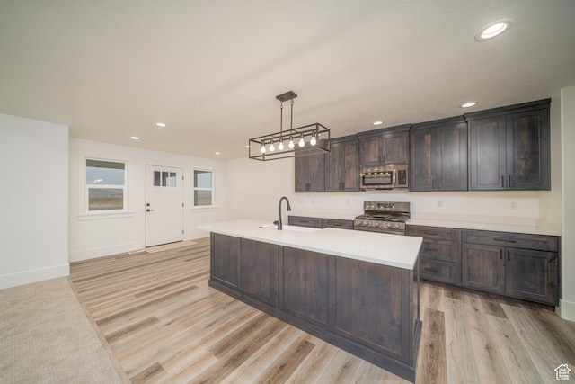 kitchen featuring pendant lighting, sink, light hardwood / wood-style flooring, dark brown cabinetry, and stainless steel appliances