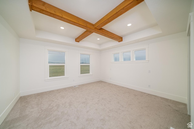 unfurnished room featuring beam ceiling and light colored carpet