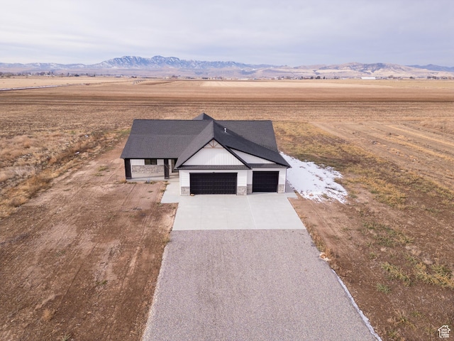view of front of home with a mountain view, a rural view, and a garage
