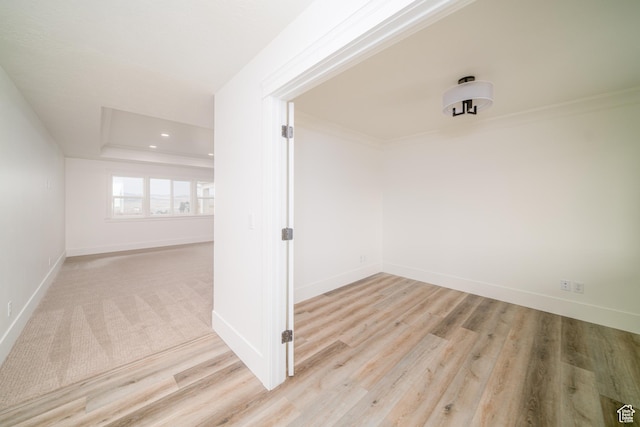 hallway with light hardwood / wood-style flooring and crown molding