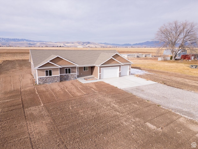 single story home with a mountain view, a porch, and a garage
