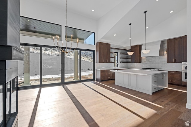 3050 Country Crossings, Heber City, UT 84032 - kitchen featuring wall chimney exhaust hood, light countertops, open shelves, a towering ceiling, and dark wood-style floors