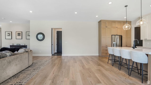 928 N Foxhunter Dr W, Farmington, UT 84025 - kitchen featuring stainless steel refrigerator with ice dispenser, open floor plan, light countertops, a kitchen bar, and a sink