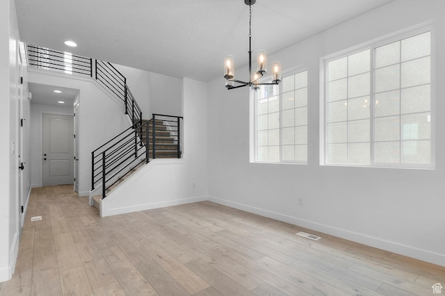 6627 W Spring Snow Ln, Herriman, UT 84096 - unfurnished dining area with a chandelier, baseboards, stairs, light wood-style floors, and recessed lighting