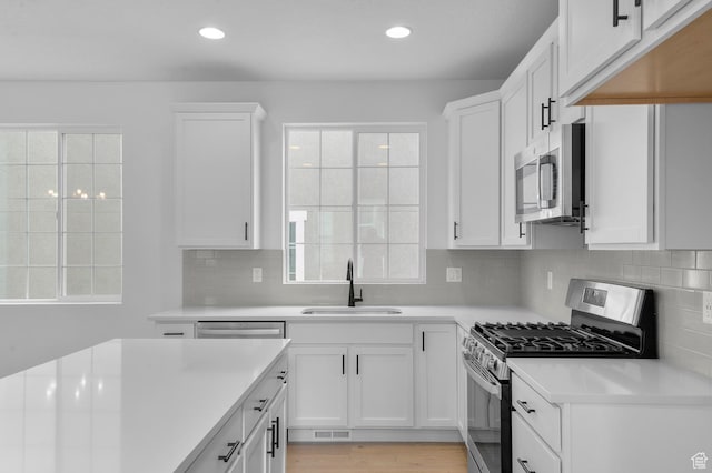 6627 W Spring Snow Ln, Herriman, UT 84096 - kitchen with a sink, appliances with stainless steel finishes, light countertops, white cabinetry, and recessed lighting
