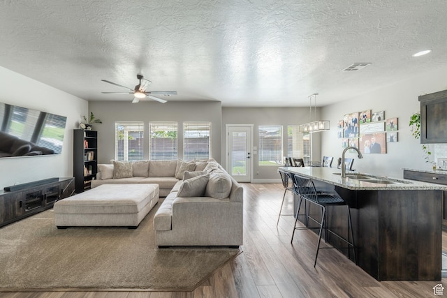 3459 S 2960 E, St George, UT 84790 - living room with ceiling fan, wood finished floors, visible vents, and a textured ceiling