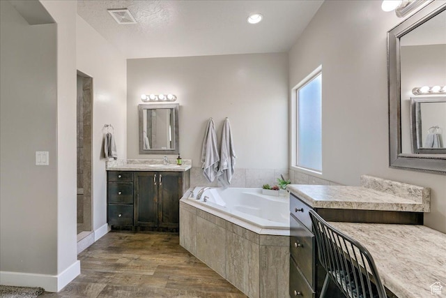 3459 S 2960 E, St George, UT 84790 - bathroom with wood finished floors, visible vents, vanity, a bath, and baseboards