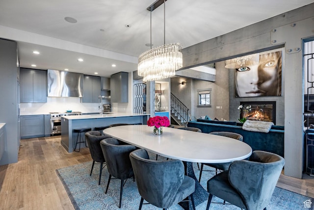 41 E Silver Star Ct Unit C-19, Park City, UT 84060 - dining room featuring a glass covered fireplace, stairs, light wood finished floors, a chandelier, and recessed lighting