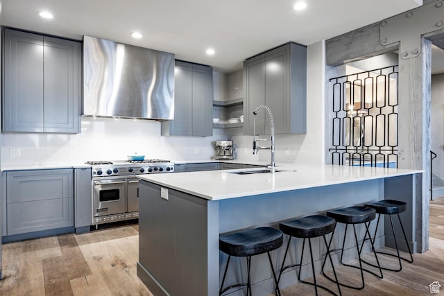 41 E Silver Star Ct Unit C-19, Park City, UT 84060 - kitchen with double oven range, exhaust hood, light wood-style floors, gray cabinetry, and a peninsula