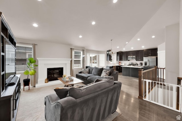 143 E 1825 N, North Ogden, UT 84414 - living area with wood finished floors, a glass covered fireplace, vaulted ceiling, and recessed lighting