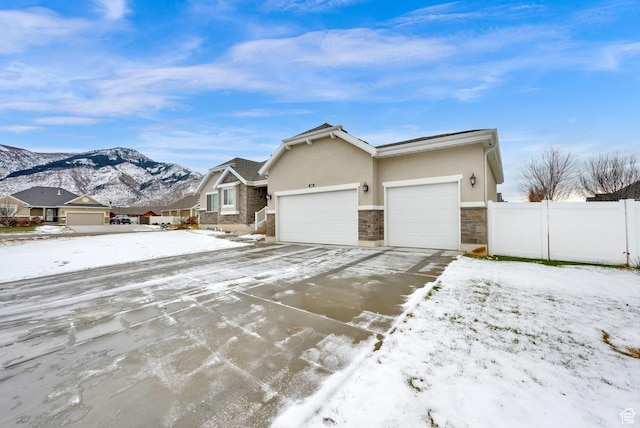 143 E 1825 N, North Ogden, UT 84414 - view of snowy exterior with concrete driveway, stucco siding, stone siding, a garage, and fence