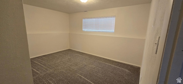 spare room with baseboards, carpet flooring, and a textured ceiling