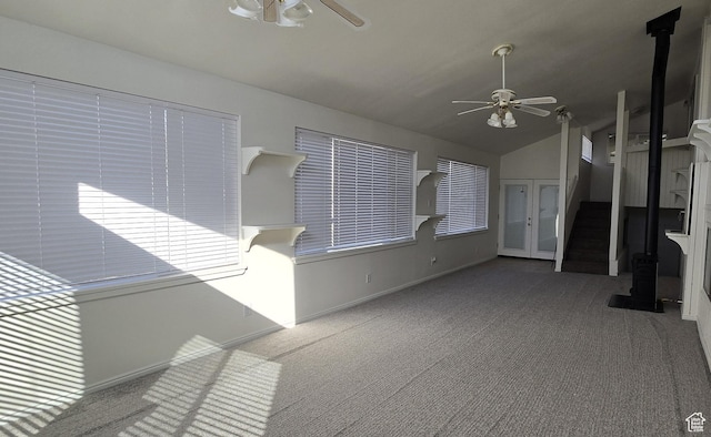 unfurnished living room featuring lofted ceiling, a ceiling fan, carpet, and stairway