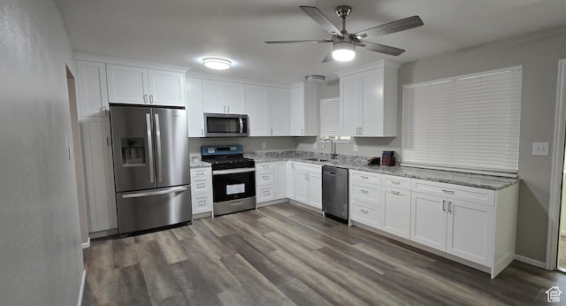 kitchen featuring white cabinets, stainless steel appliances, a sink, and ceiling fan