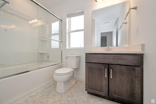 full bathroom with tile patterned floors, vanity, baseboards, toilet, and shower / bath combination with glass door