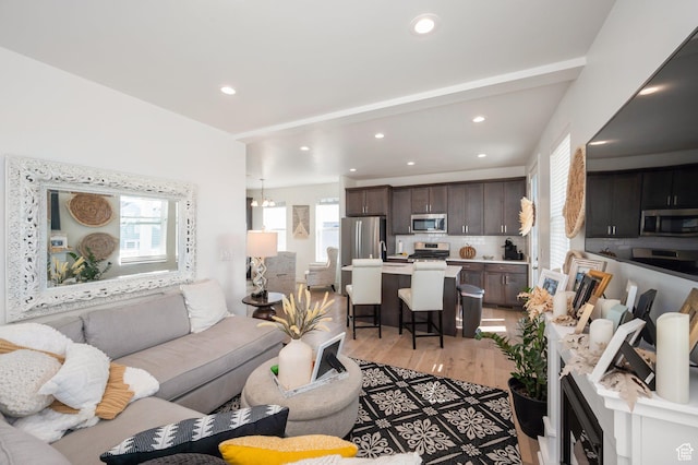living room featuring light wood finished floors, recessed lighting, and a healthy amount of sunlight