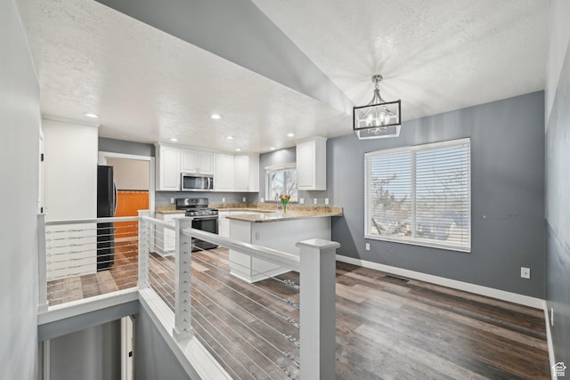 854 S 200 E, Farmington, UT 84025 - kitchen with stainless steel appliances, a peninsula, wood finished floors, white cabinetry, and baseboards