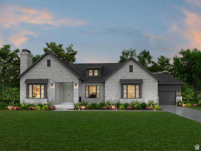 view of front of property featuring a garage and a lawn