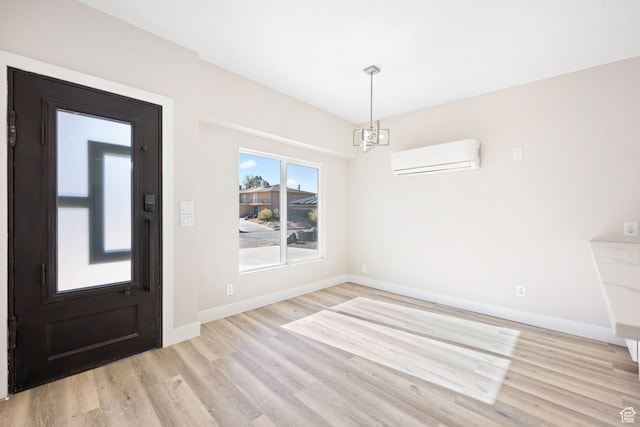 unfurnished dining area featuring a wall mounted air conditioner, light wood-type flooring, and a chandelier