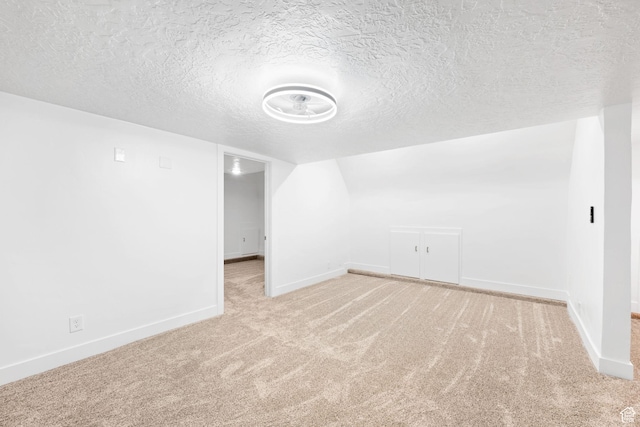 bonus room with light carpet, a textured ceiling, and vaulted ceiling