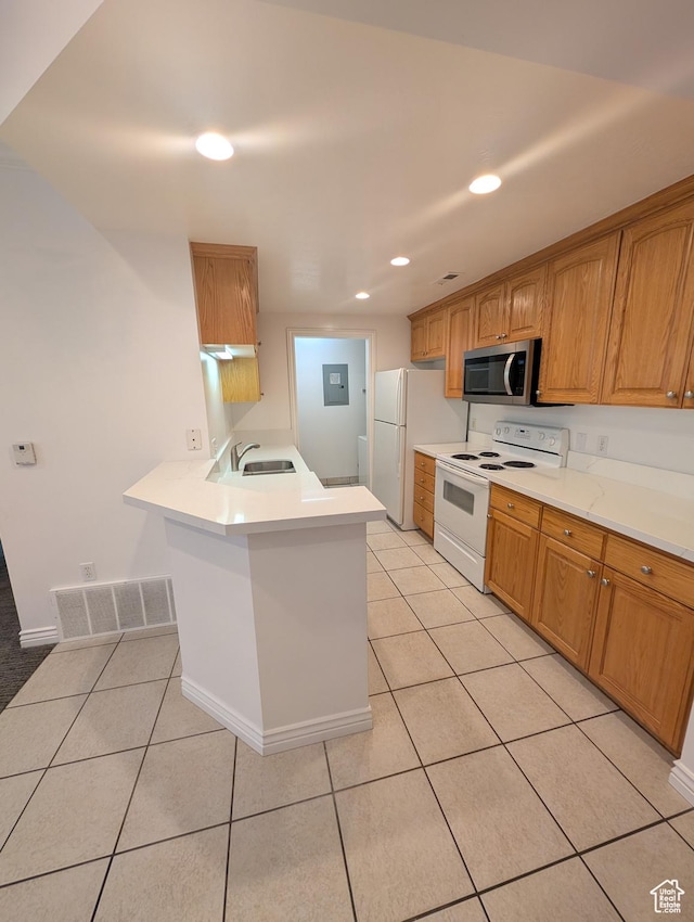 kitchen featuring kitchen peninsula, light tile patterned floors, white appliances, and sink