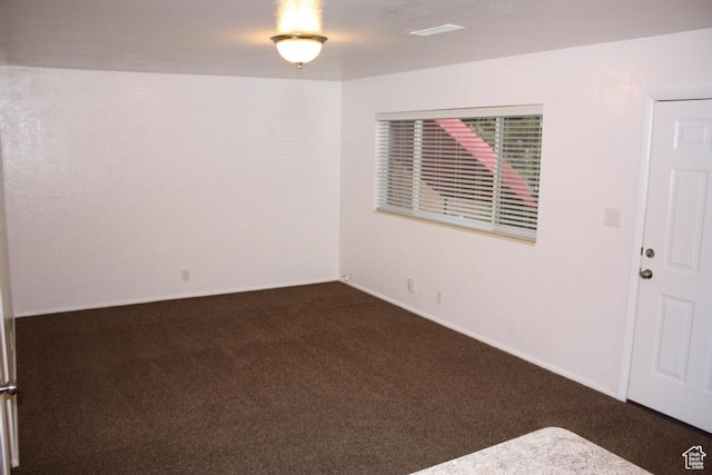 empty room with dark colored carpet