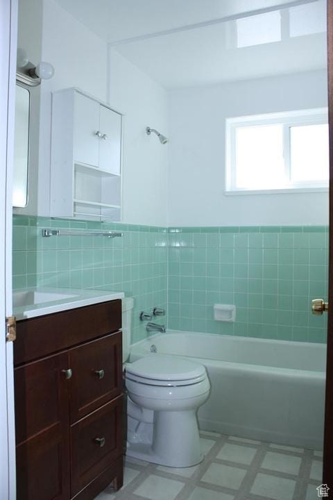 bathroom with vanity, toilet, and tile walls