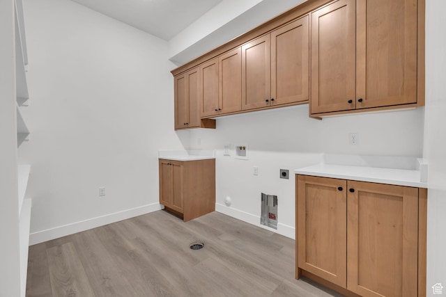 washroom with electric dryer hookup, cabinet space, washer hookup, light wood finished floors, and gas dryer hookup