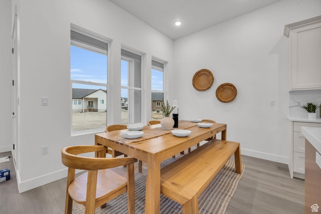 dining room featuring light wood finished floors, baseboards, and recessed lighting
