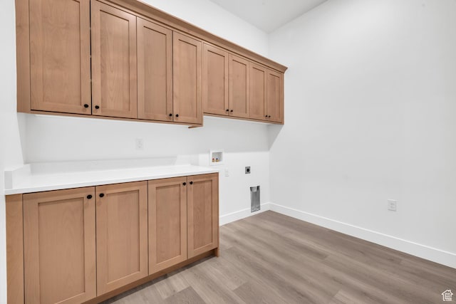 laundry room featuring cabinet space, hookup for an electric dryer, washer hookup, light wood finished floors, and baseboards