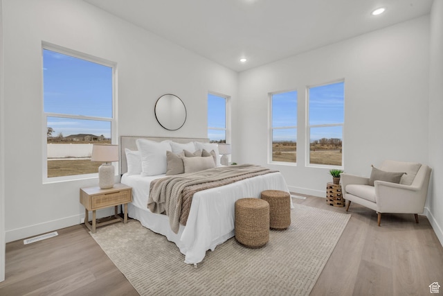 bedroom with light wood-type flooring, baseboards, and recessed lighting