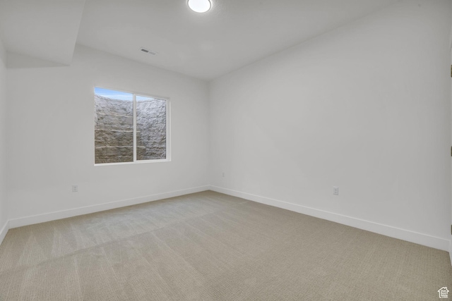 carpeted empty room featuring baseboards