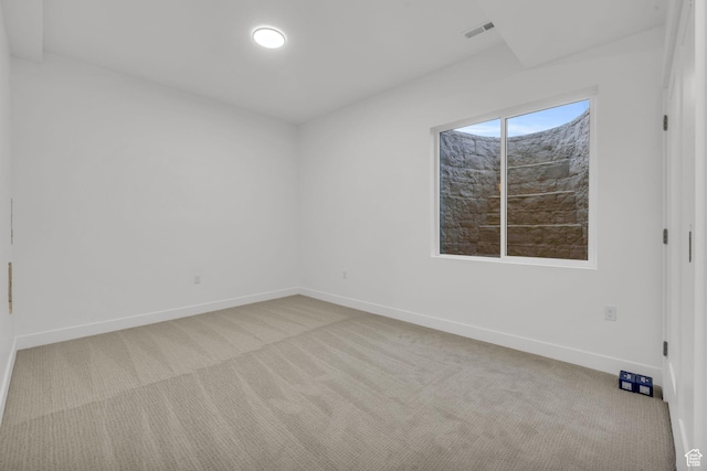 carpeted empty room featuring baseboards