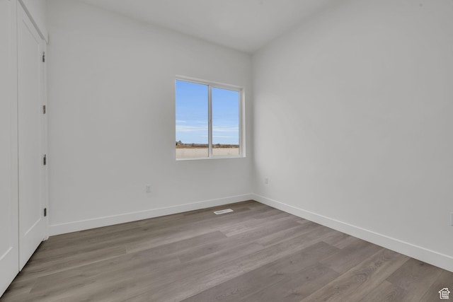 spare room with wood finished floors and baseboards