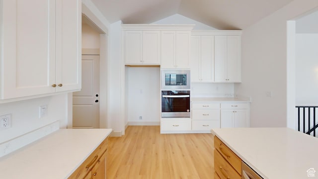 99 E 1590 S Unit 31, Salem, UT 84653 - kitchen featuring oven, built in microwave, light wood-type flooring, light countertops, and lofted ceiling